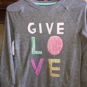 Gray sweater with sequenced writing give love.